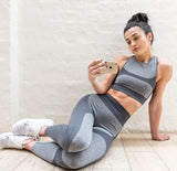 Une belle femme allongé porte le legging Sport-fitness SoShark Gris souris
