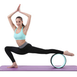 une femme utilise la roue de yoga confort vert d'eau sous la jambe