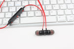 Écouteurs magnétiques Bluetooth AWEI T11 noir sidéral et rouge vif sur un clavier apple imac