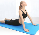 Une jolie femme fait des étirements sur un tapis de gym après sa séance de Hatha Yoga
