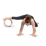 une femme utilise la roue de Yoga luxe sous le pied