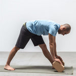 une homme utilise la brique de Yoga luxe hexagonale en liège naturel pour s'étirer