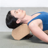 une femme utilise la brique de Yoga luxe hexagonale en liège naturel derrière sa nuque