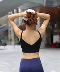 Une femme porte une brassière sport FIT.BELT noire douce et confortable