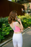 Une femme porte une brassière sport FIT.BELT rose douce et confortable