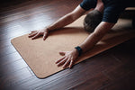 Un homme fait du Yoga sur le tapis écologique luxe en liège naturel.